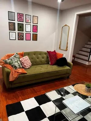 a living room with a green couch with pillows on it at Collingdale Home - Near Philly! in Collingdale