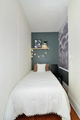 a bedroom with a white bed with a blue wall at 5 Bedroom 2 Bath Full Floor Midtown in New York