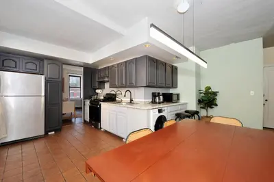 a kitchen with a wooden table and a kitchen with a dining room at 5 Bedroom 2 Bath Full Floor Midtown in New York
