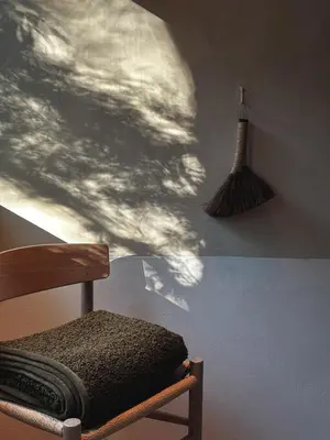 a wooden chair with a shadow of clouds on a wall at Ranch in the Woods, a Peaceful Designer Retreat in Warwick