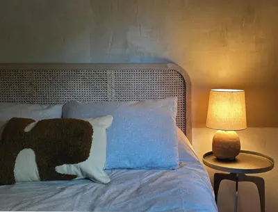 a bed with a black and white pillow and a lamp at Ranch in the Woods, a Peaceful Designer Retreat in Warwick