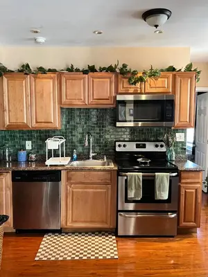 a kitchen with stainless steel appliances and wooden cabinets at Cozy 1 bedroom Abode in Philadelphia