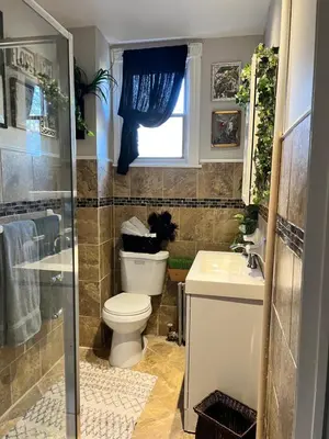 a bathroom with a toilet and a sink and a window at Cozy 1 bedroom Abode in Philadelphia