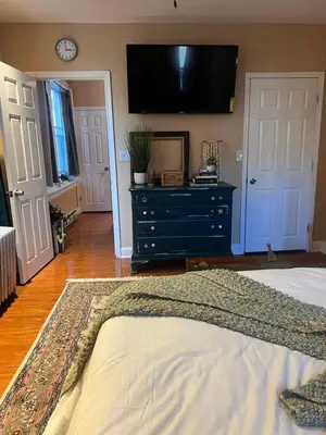a bedroom with a dresser and a tv on the wall at Cozy 1 bedroom Abode in Philadelphia
