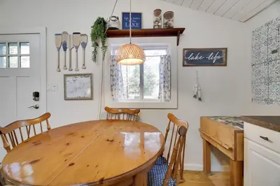 a kitchen with a wooden table and a table and chairs at Family Friendly Cabin With A Firepit And A Hot Tub In Heart of Poconos in Pocono Pines
