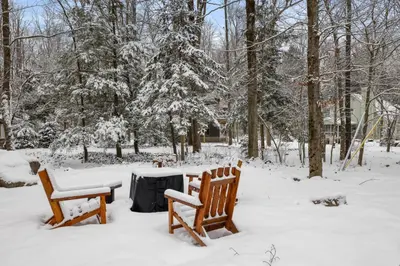 two wooden benches sitting next to a table covered in snow at Family Friendly Cabin With A Firepit And A Hot Tub In Heart of Poconos in Pocono Pines