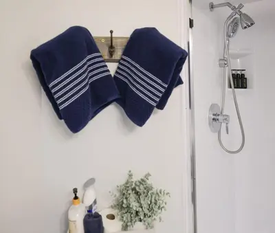 two blue towels hanging on a wall in a bathroom at Family Friendly Cabin With A Firepit And A Hot Tub In Heart of Poconos in Pocono Pines