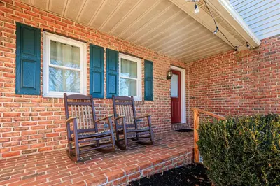 a brick house with two chairs on a porch at Serenity Inn in Ronks