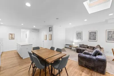 a living room with a wooden table and chairs at 105- 4BRs in the Heart of the East Village in New York