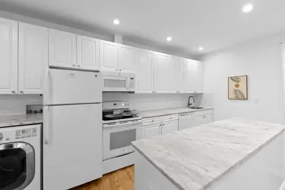 a kitchen with white appliances and a marble counter top at 105- 4BRs in the Heart of the East Village in New York
