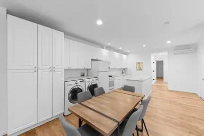 a kitchen with a table and chairs and a washer at 105- 4BRs in the Heart of the East Village in New York