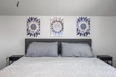a bed with two pillows and two paintings on the wall at New House within Campground in Mifflinburg