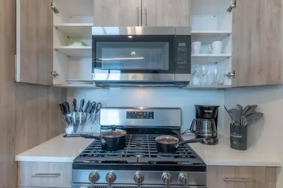a kitchen with a stove top oven with a microwave at Stylish Apt FREE Parking Near NYC & Airport in East Orange