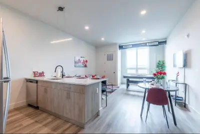 a kitchen with a sink and a table and a dining room at Stylish Apt FREE Parking Near NYC & Airport in East Orange