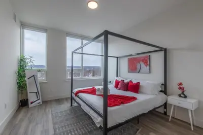 a bedroom with a canopy bed with red pillows at Stylish Apt FREE Parking Near NYC & Airport in East Orange
