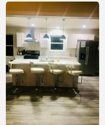 a kitchen with a counter with stools in it at Warmth Private Room in Stillwater Lake Estates