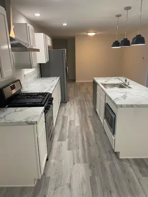 a kitchen with white counter tops and wooden floors at Warmth Private Room in Stillwater Lake Estates