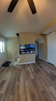 an empty living room with a tv and wooden floors at 4Bedroom2Bath7GuestSleeper in Somerdale