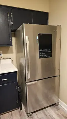 a stainless steel refrigerator in a kitchen with black cabinets at 4Bedroom2Bath7GuestSleeper in Somerdale