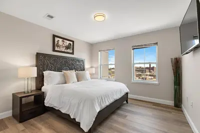 a bedroom with a large bed and two windows at City Views 1BR Free-Parking- Easy NYC Access in Newark