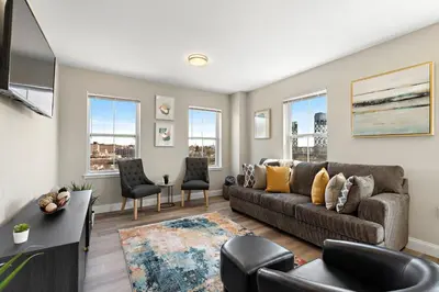 a living room with a couch and chairs and windows at City Views 1BR Free-Parking- Easy NYC Access in Newark