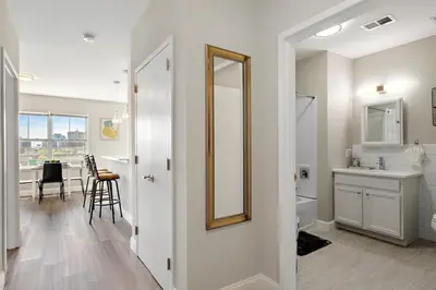 a white bathroom with a sink and a mirror at City Views 1BR Free-Parking- Easy NYC Access in Newark