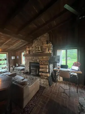 a living room with a stone fireplace and a couch at Homestead Upper Bucks - No Pet Fees in Perkasie