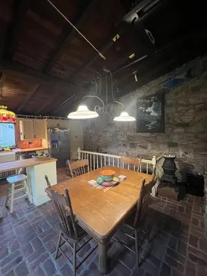 a kitchen and dining room with a wooden table at Homestead Upper Bucks - No Pet Fees in Perkasie