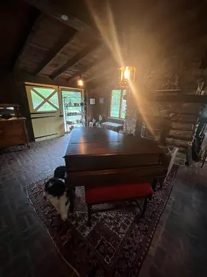 a piano in a room with a dog laying on a rug at Homestead Upper Bucks - No Pet Fees in Perkasie