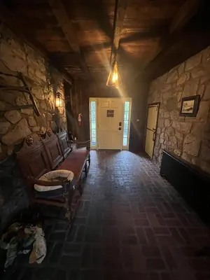 a room with a couch and a stone wall at Homestead Upper Bucks - No Pet Fees in Perkasie