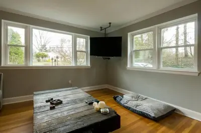 a living room with a wooden table and windows at K9 Cottage MainLine in Berwyn