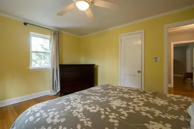 a bedroom with a bed and a dresser and a window at K9 Cottage MainLine in Berwyn
