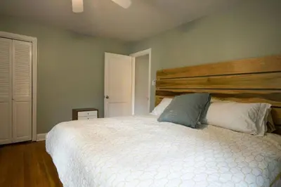 a bedroom with a large bed with a wooden headboard at K9 Cottage MainLine in Berwyn
