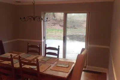 a dining room with a wooden table and a window at K9 Cottage MainLine in Berwyn