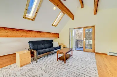 a living room with a blue couch and a table at Golf, Fish and Ski Retreat with Game Room in Thompson in Thompson