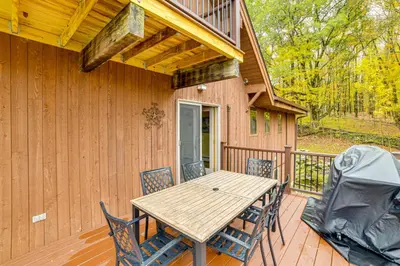 a porch with a wooden table and chairs on a deck at Golf, Fish and Ski Retreat with Game Room in Thompson in Thompson