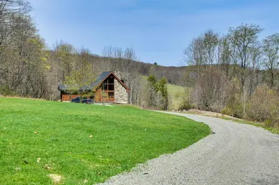a gravel road leading to a cabin on a hill at Golf, Fish and Ski Retreat with Game Room in Thompson in Thompson