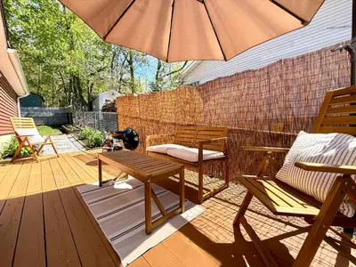 a patio with a table and an umbrella at Peak to Lake Escape in Greenwood Lake