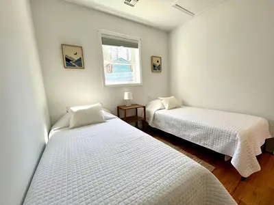 two beds in a small room with a window at Peak to Lake Escape in Greenwood Lake