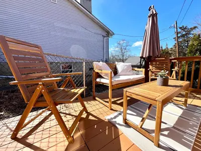 a patio with two chairs and a table and an umbrella at Peak to Lake Escape in Greenwood Lake