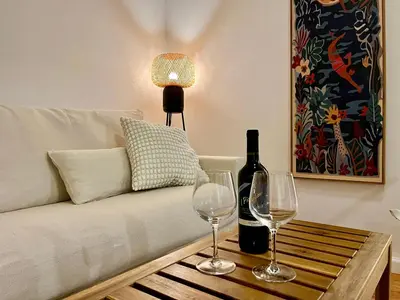 a living room with a couch with two wine glasses at Peak to Lake Escape in Greenwood Lake