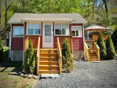 a tiny house with a porch and a door at Peak to Lake Escape in Greenwood Lake