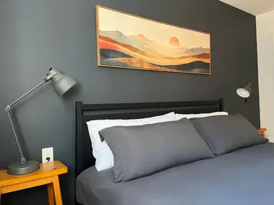 a bedroom with a bed and a painting on the wall at Peak to Lake Escape in Greenwood Lake
