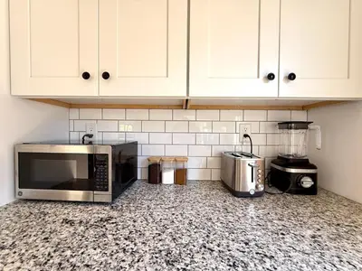 a kitchen with a microwave and a blender on a counter at Peak to Lake Escape in Greenwood Lake