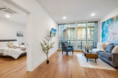 a living room with a bed and a couch at Chic 1BR Retreat - Pool, Gym Balcony Views in Philadelphia