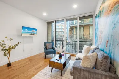 a living room with a couch and a table at Chic 1BR Retreat - Pool, Gym Balcony Views in Philadelphia