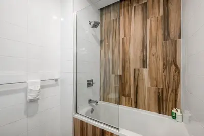 a bathroom with a shower with a wooden wall at Chic 1BR Retreat - Pool, Gym Balcony Views in Philadelphia