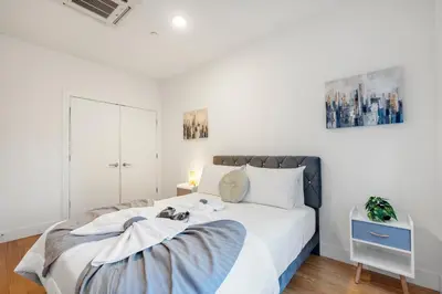 a bedroom with a large white bed in a room at Chic 1BR Retreat - Pool, Gym Balcony Views in Philadelphia