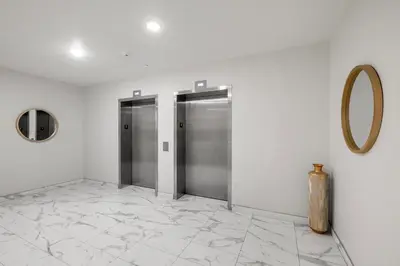 a hallway with two elevators and a mirror on a wall at Chic 1BR Retreat - Pool, Gym Balcony Views in Philadelphia