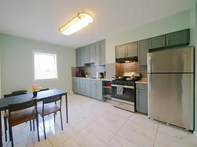 a kitchen with a table and a stainless steel refrigerator at New Studio unit near the heart of NYC in Jersey City